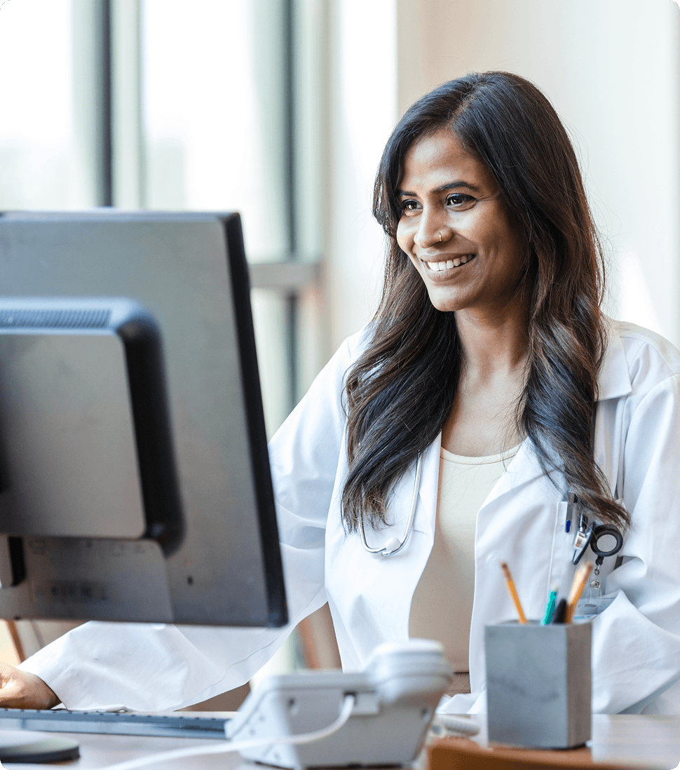 Doctor smiling while using computer