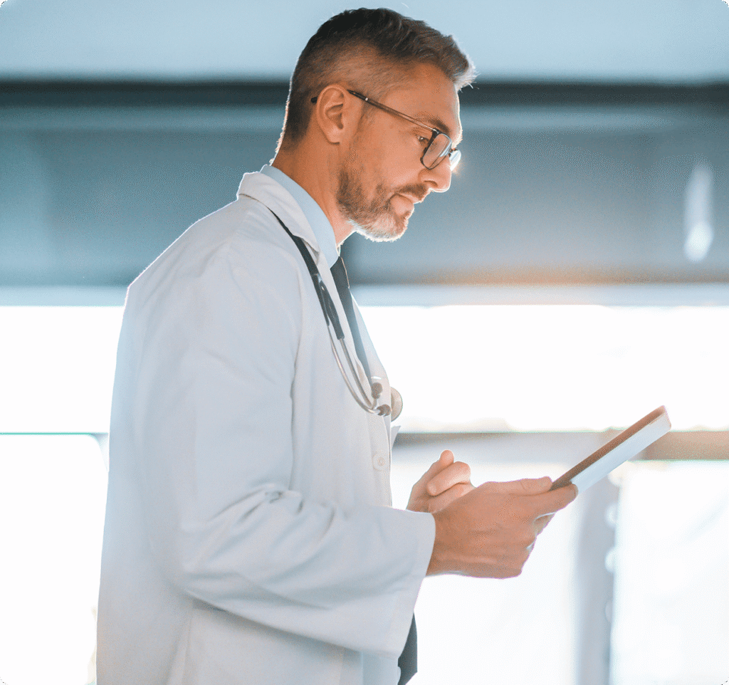 Male doctor looking at tablet computer
