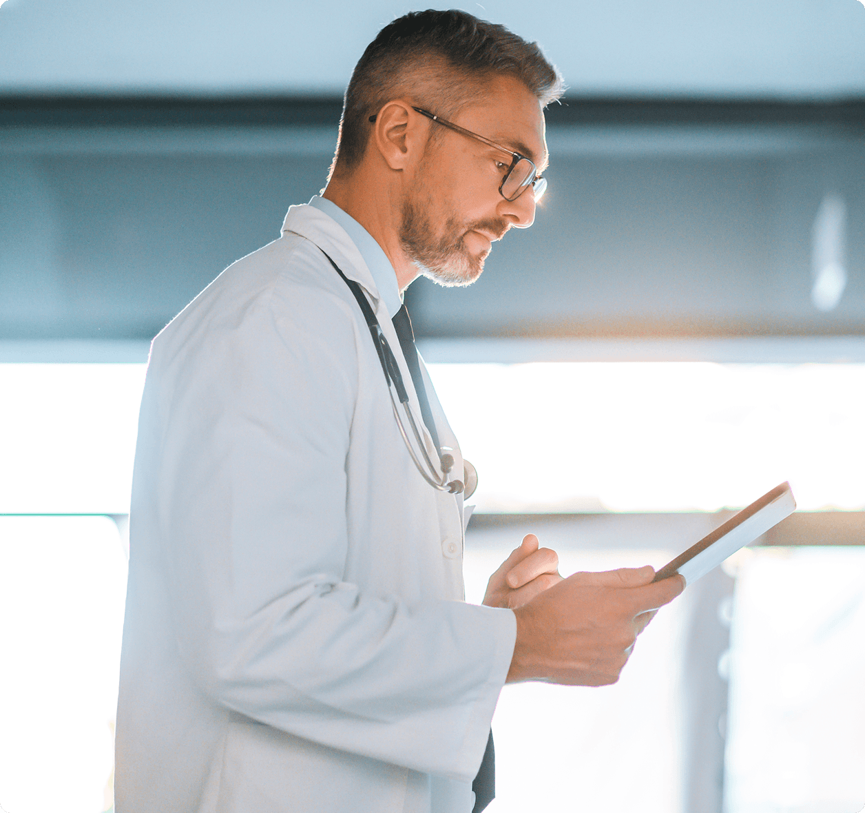 Male doctor looking at tablet computer