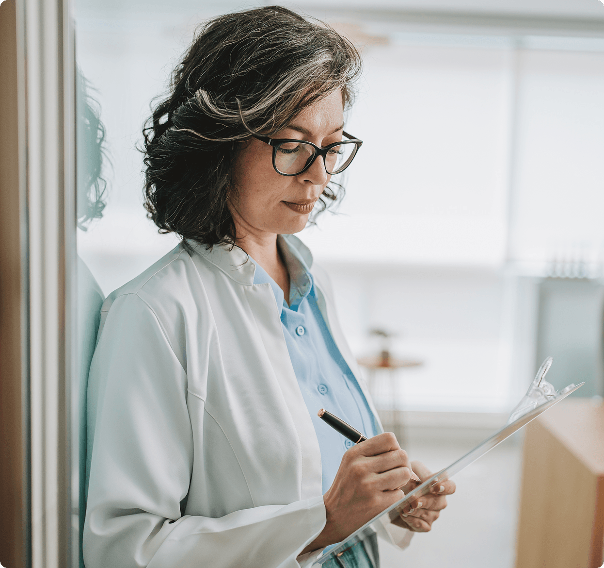 Female doctor writing on clipboard